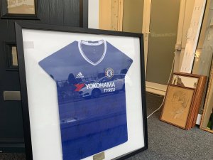 A glass framed, signed football shirt from Chelsea